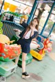 A woman in a school uniform standing next to a carousel.