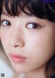 A close up of a woman's face with brown eyes.