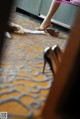 A woman is putting on her wedding shoes on the floor.