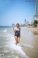 A woman in a bathing suit running into the ocean.