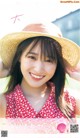 A woman in a straw hat smiles at the camera.