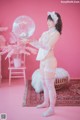 A woman in a white lingerie holding a large bubble.