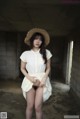 A woman in a white shirt and a straw hat posing for a picture.