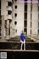 A woman in a blue and white outfit is sitting on some steps.